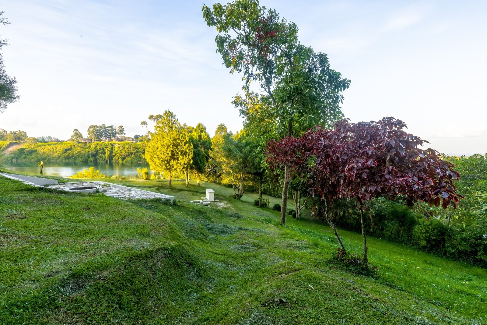 Open camping lawns with space for tents and a night fire near Fort Portal