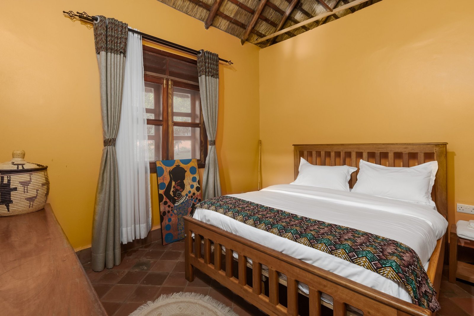 Second family cottage bedroom with garden light and natural textures at Bahundu near Fort Portal, Uganda