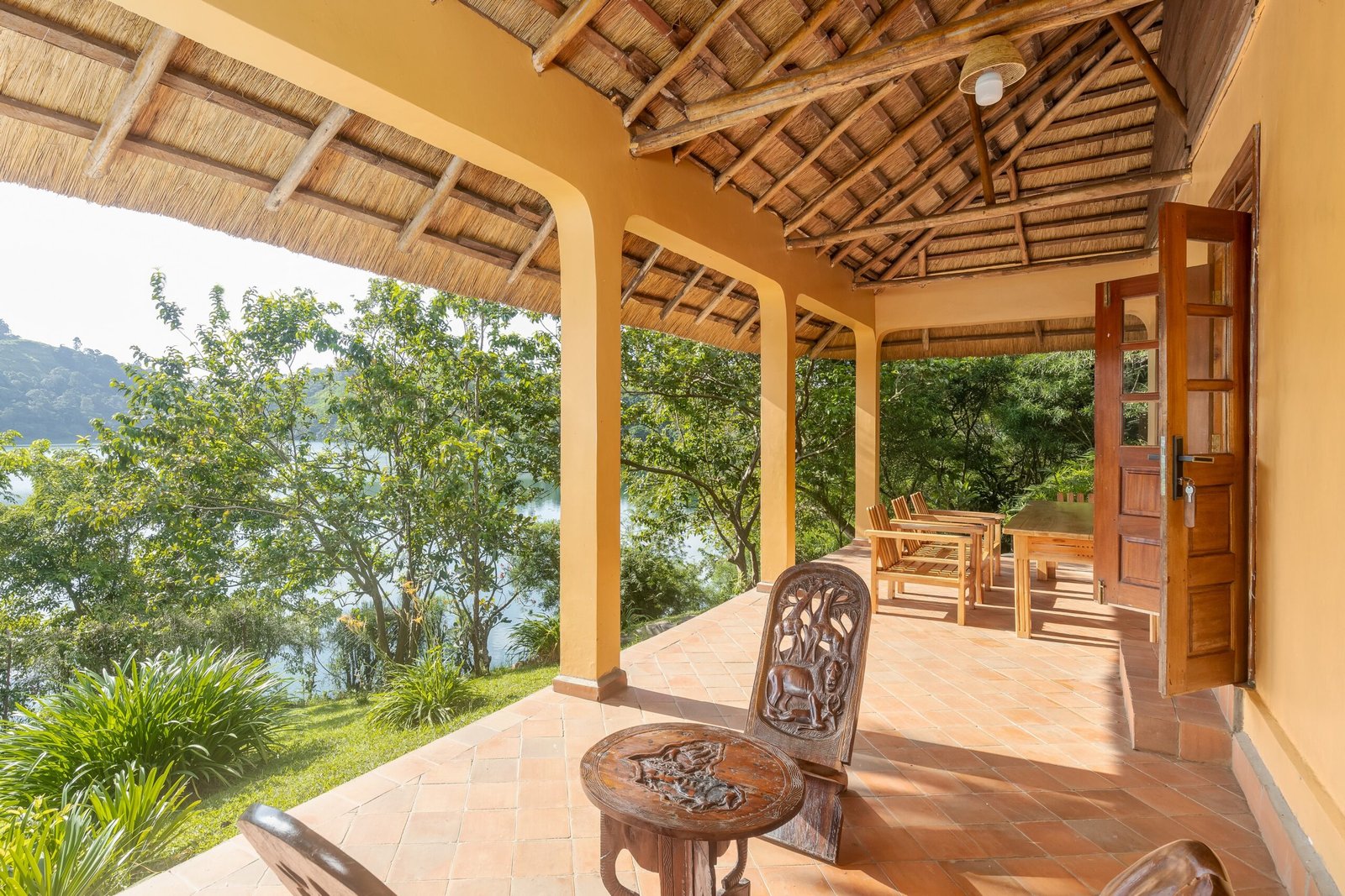 Wide family cottage veranda looking across the gardens toward Lake Nyinabulitwa