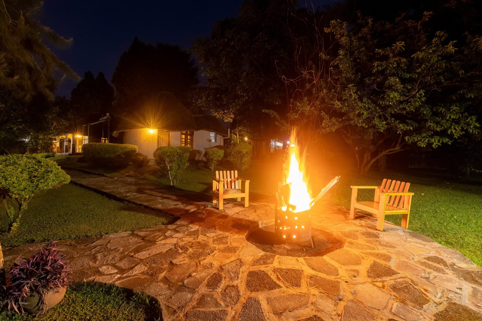 Guests gathered around the garden firepit on a quiet night at Bahundu near Fort Portal in western Uganda