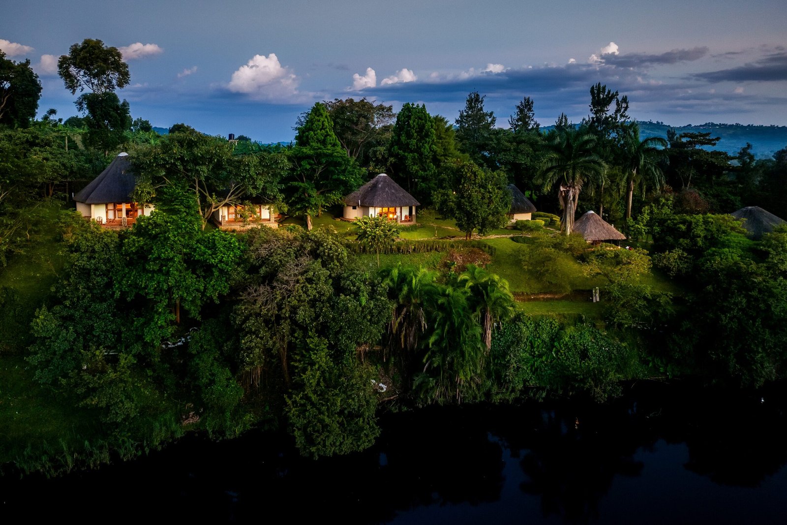 Aerial dusk settling over Bahundu Safari Lodge and the crater lake at the quiet crater lake retreat near Kibale Forest