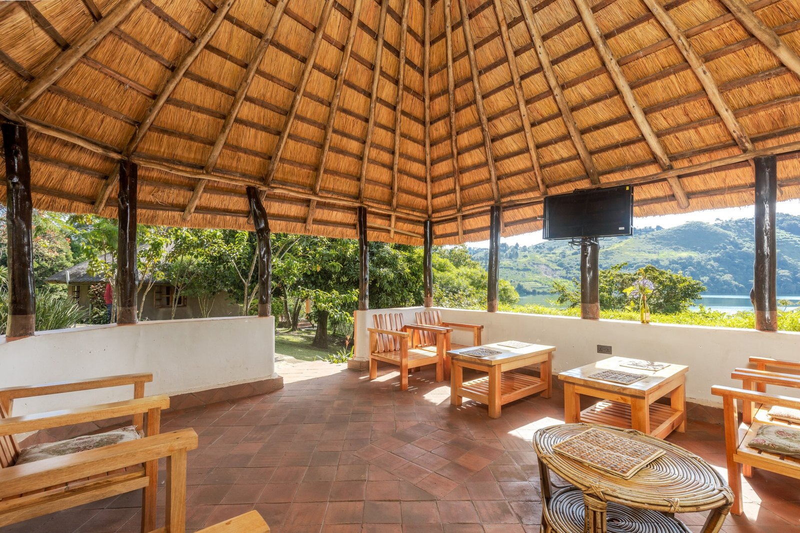 Inside the open thatched dining pavilion, looking out to the crater lake
