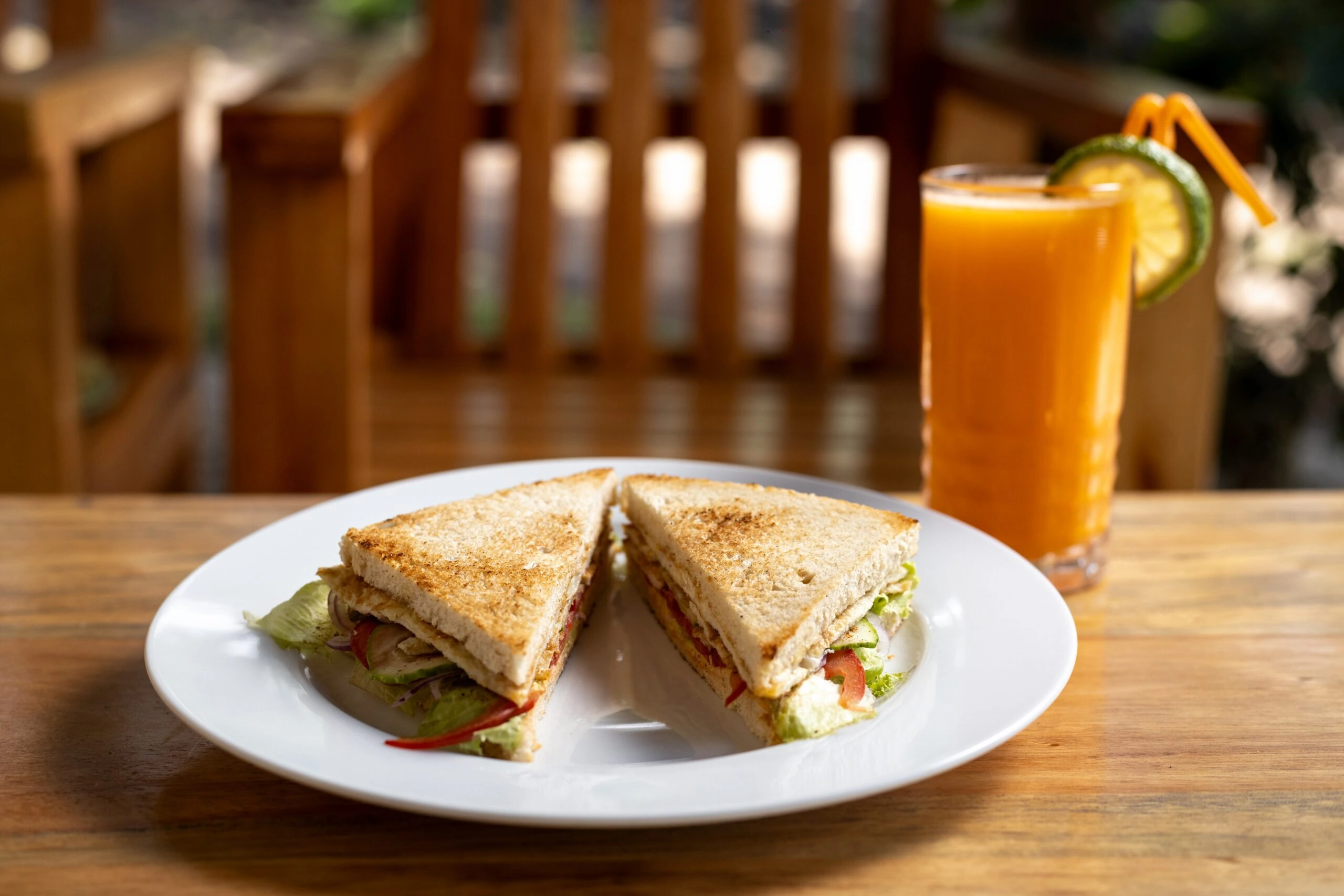 Toasted breakfast sandwich with sliced fruit and fresh juice at Bahundu in western Uganda, East Africa