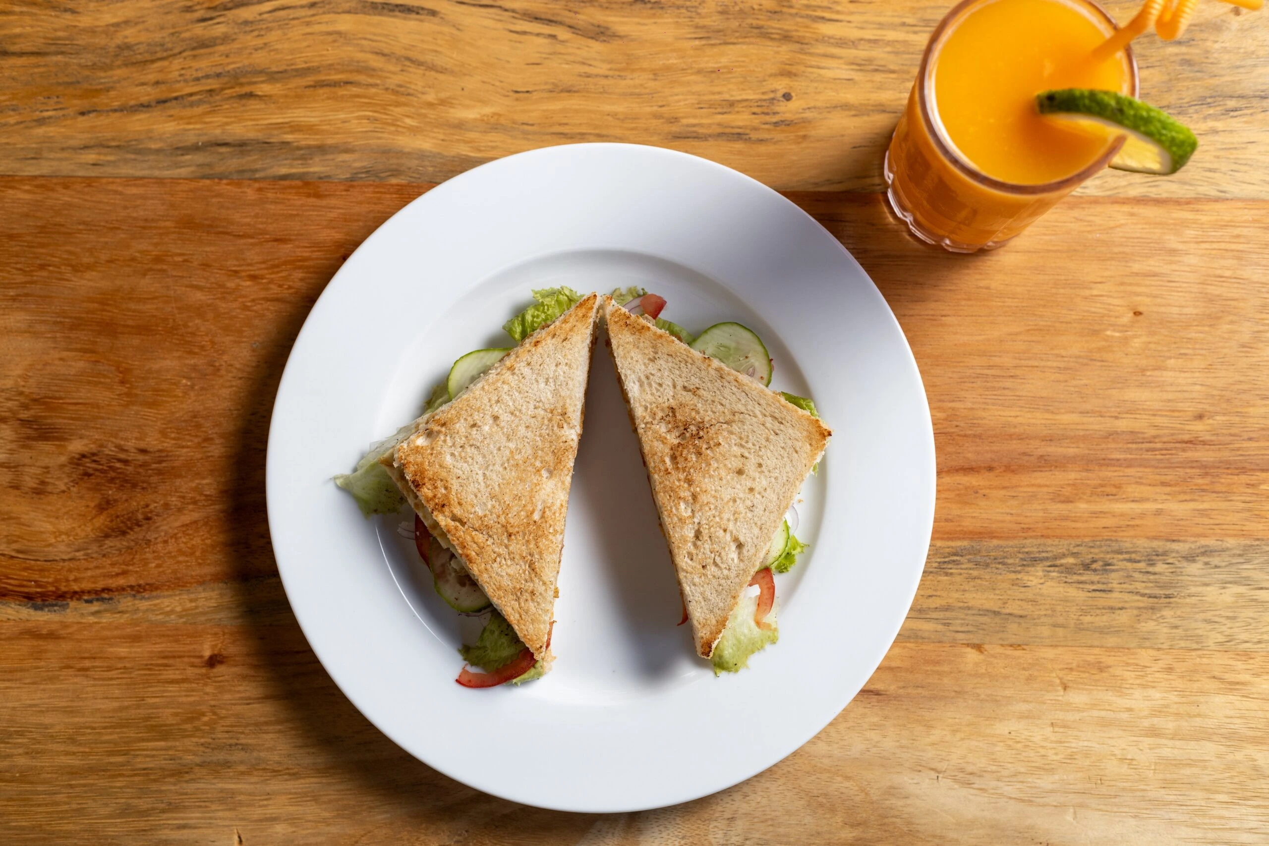 Toasted breakfast sandwich served with fruit and fresh juice at the lakeside retreat near Kibale Forest in western Uganda