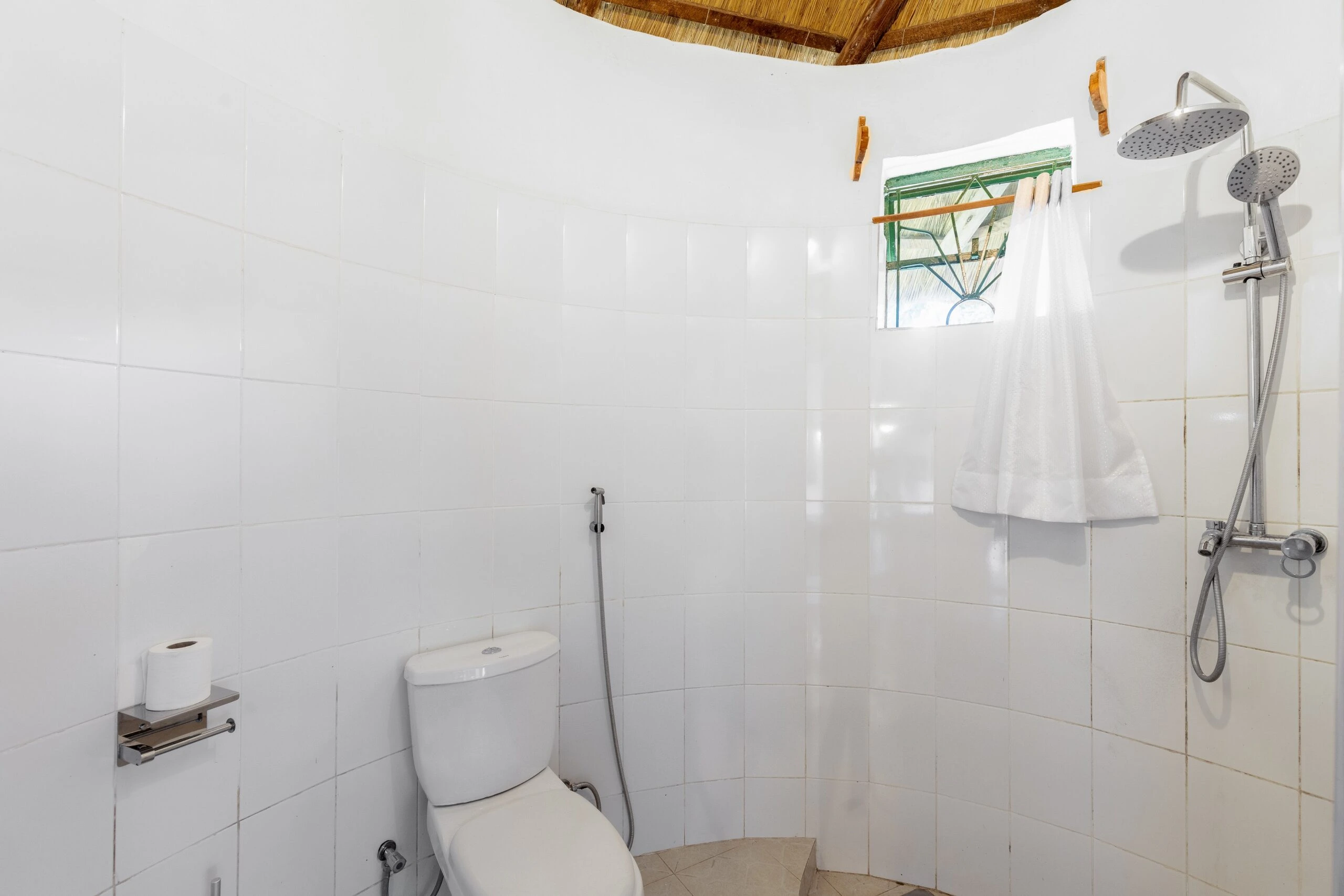 White tiled cottage bathroom with twin rain showers at Bahundu near Fort Portal, Uganda