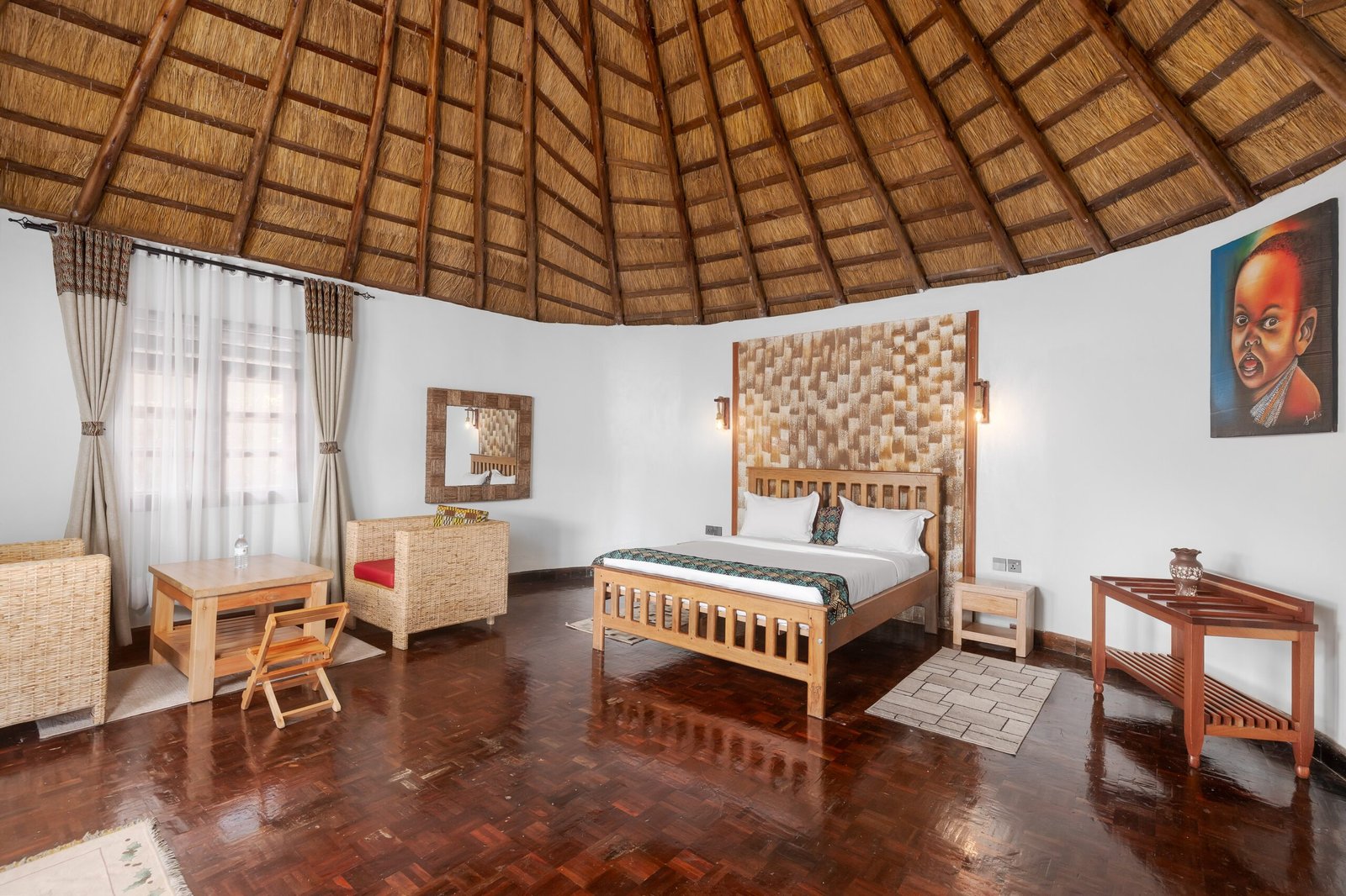 King size bed beneath a high thatched roof in a cottage for two at the quiet crater lake retreat in western Uganda